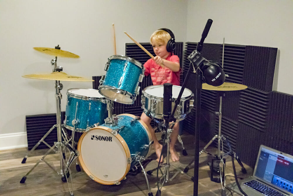 Child playing drums in the renovated basement