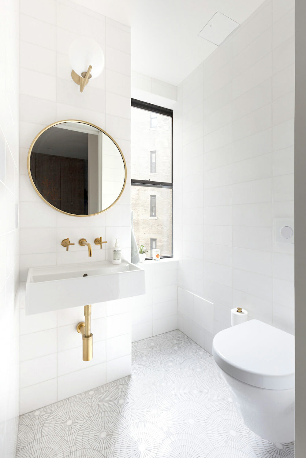 powder room with graphic floor tile and gold fixtures