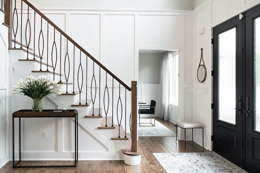 Entryway with black doors and staircase